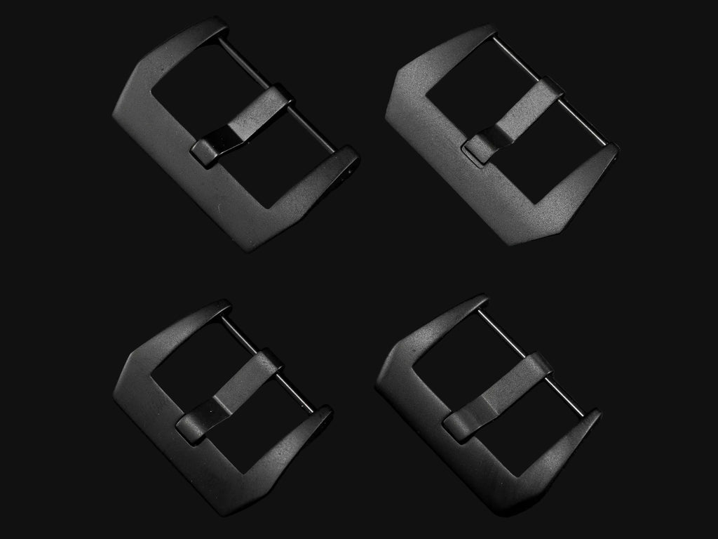 Four black watch buckles of different sizes on a dark gray background